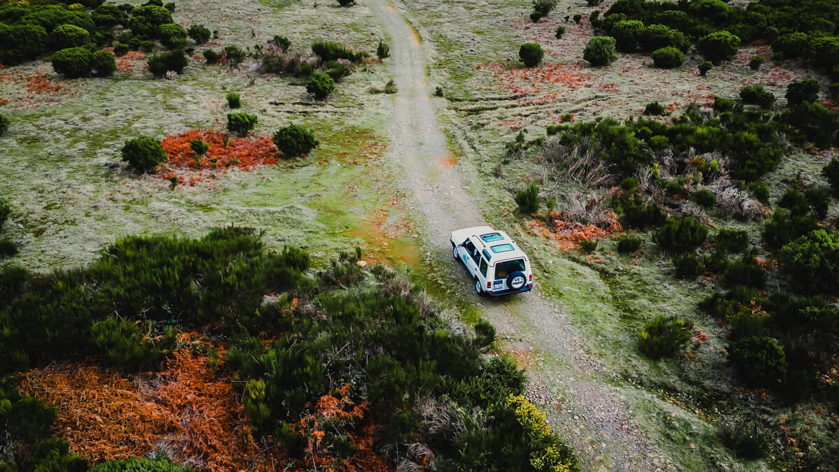 Drone shot of a jeep driving threw wild nature in madeira