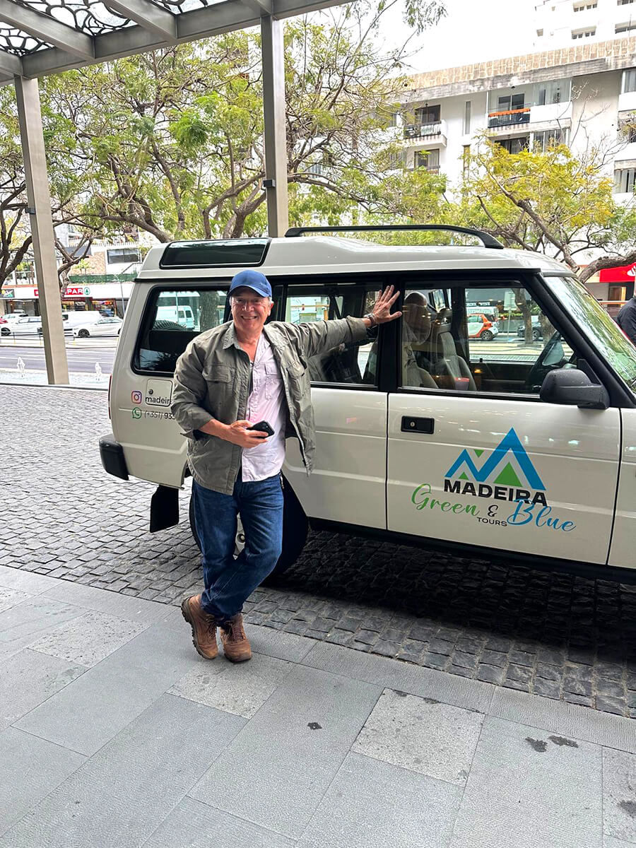 A massive waterfall dropping from a high cliff surrounded by green nature